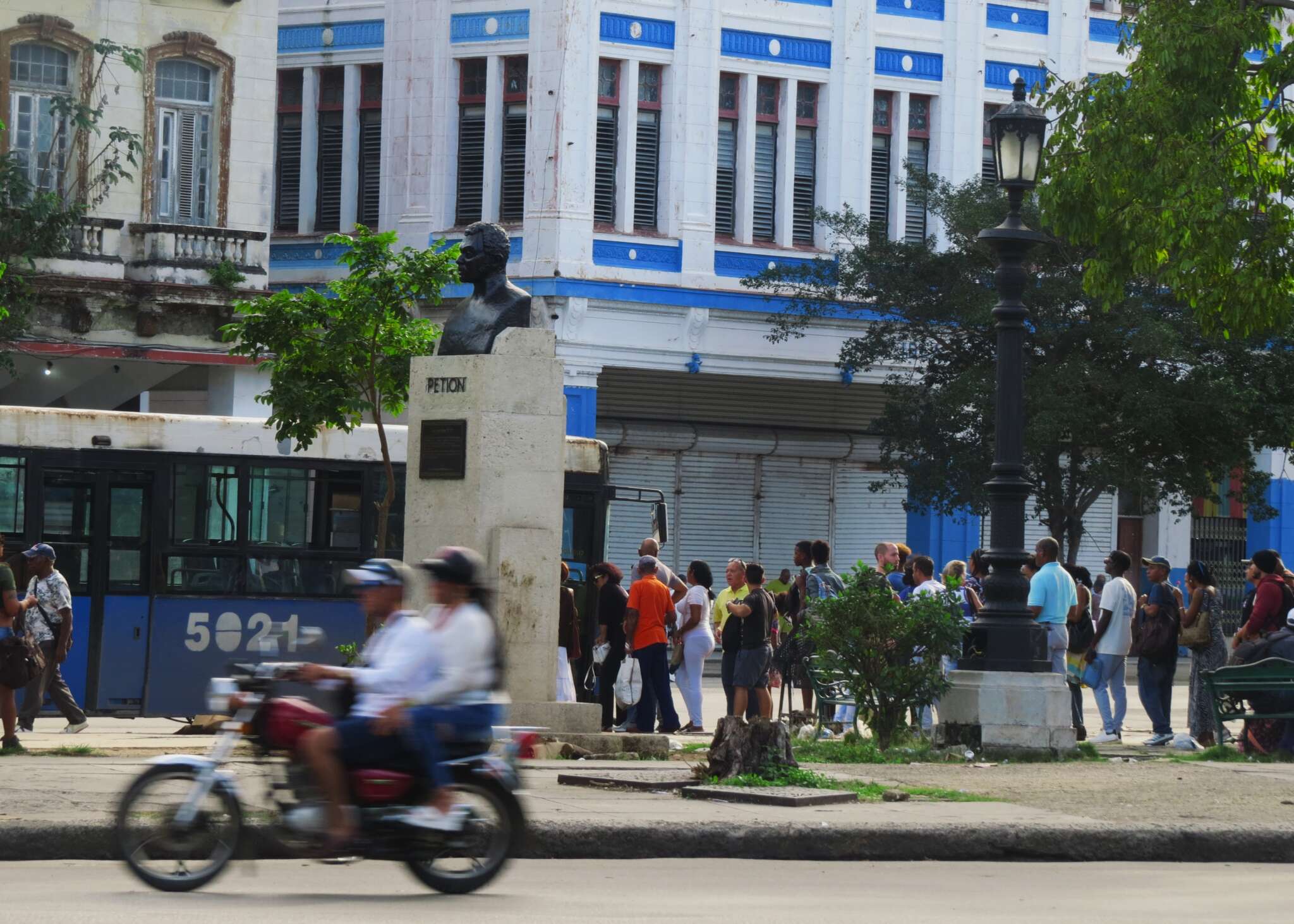 People lining up for a bus in a main intersection of Havana, Cuba.