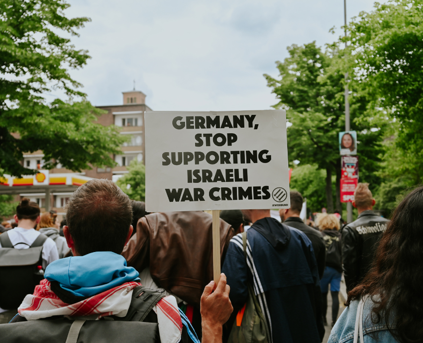 protester holding a sign saying 'Germany stop supporting Israel's war crimes'