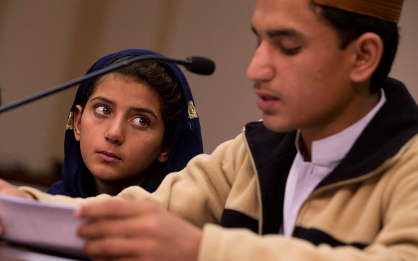 Nine-year-old Nabila Rehman (left) watches as her brother Zubair reads a statement.