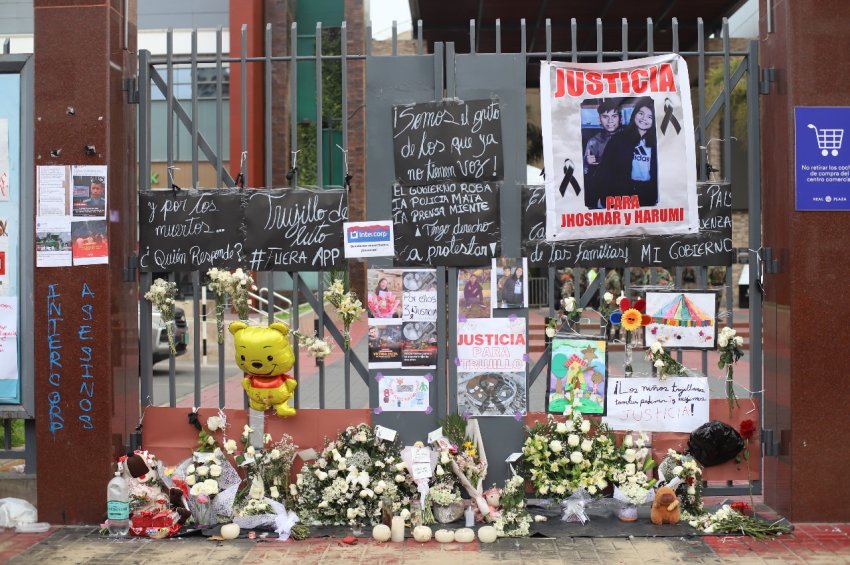 Messages to remember those who died are attached to a fence