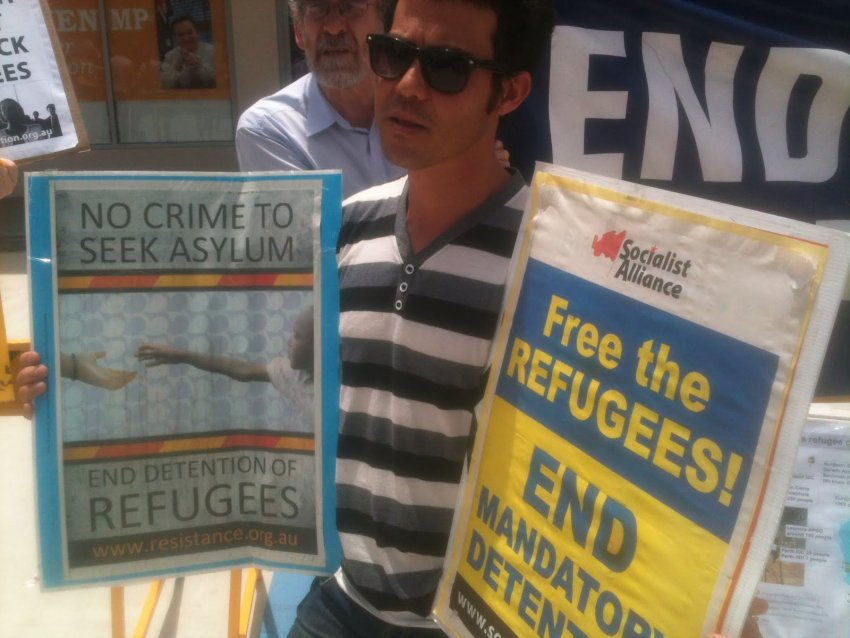 A protester at the rally with a placard. Photo: Paul Benedek.