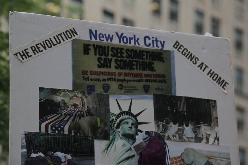 Placard that reads "New York City The Revolution Begins At Home".