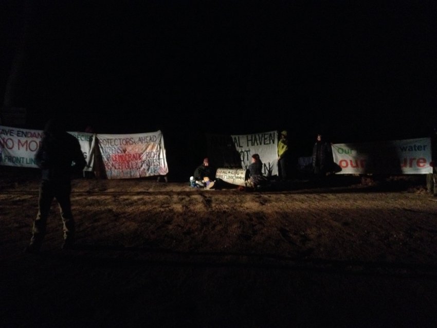 Protesters with banners and two people locked-on.