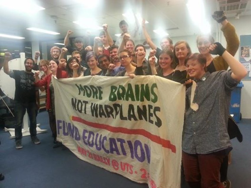 Students with the banner featured in the Q&A protest on May 5.