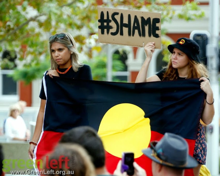 Protesters holding Aboriginal flag and placard that reads 'Shame'