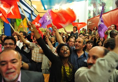 Activists wave left Bloc flags.