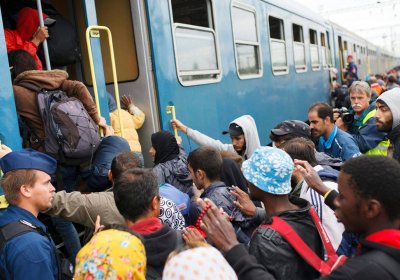 Refugees board a train at the Serbia-Hungary border town of Zakany, Hungary, 20 September 2015.