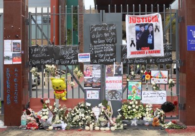 Messages to remember those who died are attached to a fence