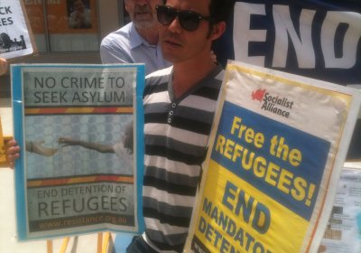 A protester at the rally with a placard. Photo: Paul Benedek.