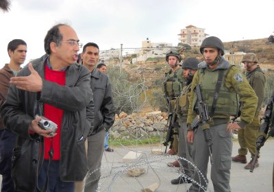 Mazim Qumsiyeh argues with Israeli soldiers.