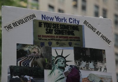 Placard that reads "New York City The Revolution Begins At Home".