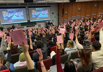 students raise their hands to vote for the motion